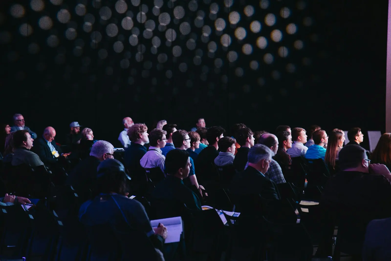 Rows of people seated in a conference room, facing the front